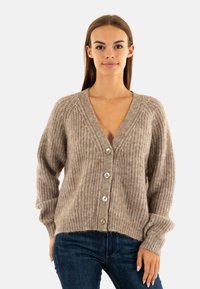 Cardigan lavorato a maglia beige con scollo a V, texture a coste e cinque bottoni sul davanti. Presenta maniche lunghe e una vestibilità rilassata.