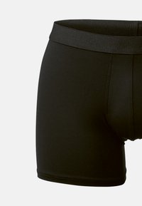 Musta puuvillasekoite boxer-shorts, joissa on leveä joustava vyötärö, sileä pinta ja lyhyet lahkeet, joissa on litteät saumat eikä näkyviä kuvioita.