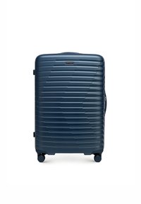 Harde koffer in marineblauw, met een gestructureerd oppervlak met horizontale groeven, ingevoerde wielen en een zijhandgreep voor draagbaarheid.