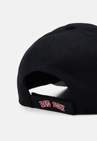 Schwarze Baseballkappe aus strukturiertem Material, mit roter "RED SOX" Stickerei am Hinterriemen und einem runden oberen Design.