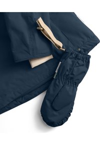 Marineblauwe waterdichte jas met beige accenten en een bijpassend paar wanten. Heeft een gladde textuur en elastische manchetten voor een goede pasvorm.