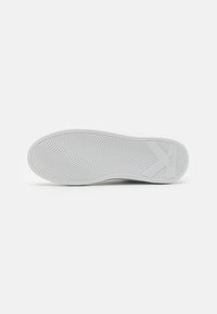 Sole di scarpa in gomma bianca con motivo a onde testurizzato, dotata di un logo e un bordo liscio. Il design è semplice e minimalista.