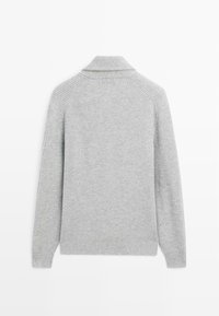 Grå stickad tröja med ribbad textur, med en sjalkrage och raglanärmar. Baksidan är sömlös vilket betonar en ren design.