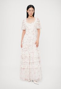 Biela kvetinová róba s volánovými vrstvami a priehľadnými nafúknutými rukávmi. Má priliehavý živôtik a vzdušný strih, doplnený jemným potlačou.