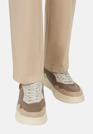 Sneaker in tonal beige e marrone, con un design in materiali misti che presenta accenti in suede, una suola intermedia testurizzata e lacci bianchi.
