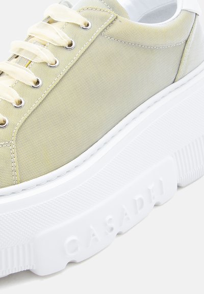 Φωτεινό πράσινο αθλητικό παπούτσι με υφή, εκρού κορδόνια και χοντρή λευκή σόλα πλατφόρμα με ανάγλυφο το λογότυπο "CASADEI".