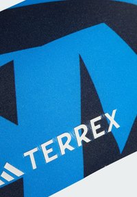 Tela azul y negra con un acabado texturizado, que presenta un logotipo destacado que dice "TERREX" en blanco, junto con formas gráficas audaces.