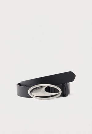 Cintura in pelle nera con fibbia ovale in argento dal design liscio e curvo, posata arrotolata su sfondo bianco.