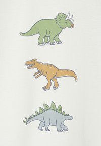 T-Shirt mit drei Cartoon-Dinosauriern: einem grünen Triceratops, einem orangefarbenen T. rex und einem blauen Stegosaurus, alles auf weißem Hintergrund.