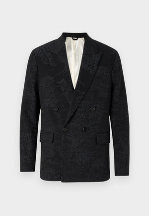 Blazer noir à double boutonnage présentant un tissu texturé avec des motifs subtils, des revers crantés et deux poches avant. Intérieur doublé.