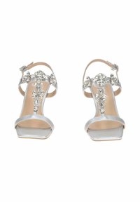 Sandali alti argentati con tacco, caratterizzati da cinghie decorate con gemme trasparenti. La texture liscia è abbinata a un design con punta quadrata.