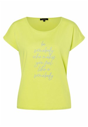 Gelbes Kurzarmshirt mit rundem Ausschnitt, vorne mit silbernem Schriftzug: „Sei jemand, der dich wie jemanden fühlen lässt“.