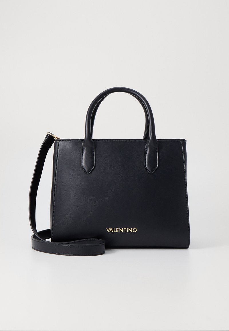 Juodas odinis torkos maišas su dviem rankenomis ir nuimamu peties diržu. Priekyje yra auksinis "VALENTINO" logotipas. Paprastos stačiakampio formos.