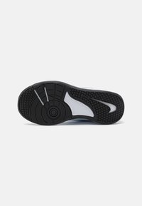Crna guma na potplatu s valovitom teksturom, kružno izrađenim dizajnom u središtu i bijelim detaljem u obliku swoosh s strane.