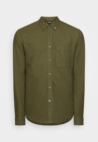 Camicia verde oliva a maniche lunghe con bottoni, colletto abbottonato e taschino sul petto sinistro su sfondo semplice.