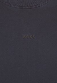 Mörkblå sweatshirt med ribbad textur och rundad halsringning; "BOSS"-logotyp i svart placerad centralt på bröstet.