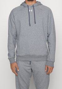 Felpa grigia realizzata in tessuto morbido, con tasca a marsupio, cordini regolabili e polsini a coste. Logo mostrato sul petto.