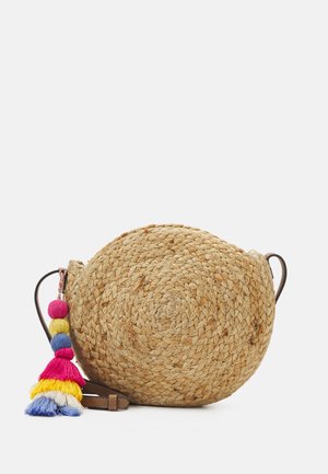 Okrągła pleciona torba ze słomy na ramię z wielokolorowym frędzlem i brązowym skórzanym paskiem na białym tle.