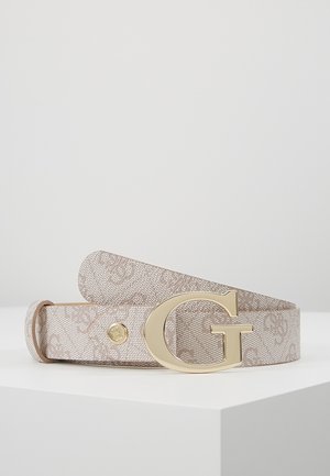 Beżowy pasek w wzory z pozłacaną klamrą w kształcie litery „G”, zwinięty i spoczywający na białej powierzchni na tle jednolitego szarego tła.