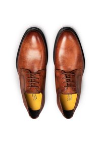 Chaussures habillées en cuir marron avec une finition lisse, un bout arrondi et un laçage à six œillets. L'intérieur est doublé de rembourrage jaune.