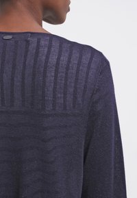 Námořnický svetr s texturovaným zadním dílem s vertikálním žebrováním, měkkým pleteným materiálem a malým knoflíkovým detailem u výstřihu.