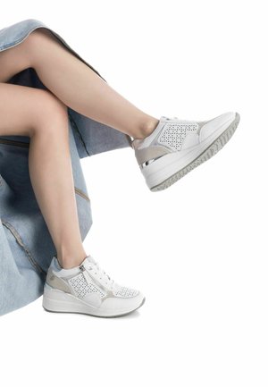Sneaker bianchi e grigi con design perforato, chiusura con lacci e zip, suola piattaformata imbottita e dettagli riflettenti.