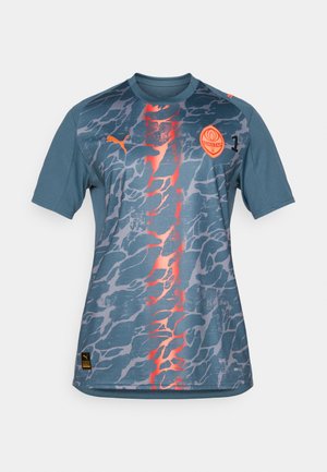 Korte mouwen blauwe jersey met een verloop camouflagepatroon, voorzien van oranje accenten, een logo en een ronde halslijn. Gemaakt van ademend materiaal.