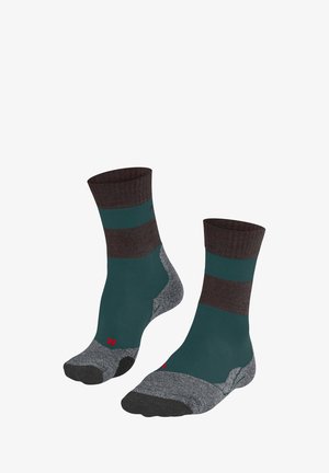Un paio di calzini a tubolare che presentano un polsino a coste di colore marrone scuro, un corpo teal con righe orizzontali e una suola grigia con dettagli del logo rosso.