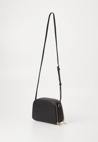 Borsa a tracolla nera realizzata in materiale liscio, con forma arrotondata, due scomparti con zip e dettagli in hardware tono oro.