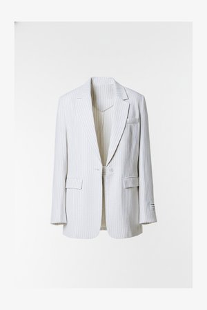 Valge triibuline jakk sälklapiga, ühe nupuga, nelja taskuga ning tekstuurse kangaseelisega.