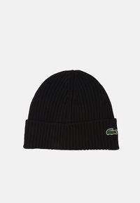 Svart ribbad stickad mössa med nedvikt kant och en liten grön krokodil-logotyp på sidan. Tillverkad av ett mjukt, stretcht material.