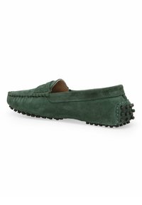 Grüne Wildleder-Mokassinschuhe mit flachem Design, Gummisohle mit Noppen und sichtbaren Nähten entlang der Kanten für zusätzliche Details.