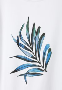 Chemise blanche ornée d'un motif de feuilles bleu et noir, avec des nuances de bleu en style aquarelle et une texture de tissu douce.