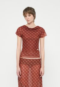 Red checkered top with a draped neckline and short sleeves, made of sheer fabric, paired with a matching sheer skirt.