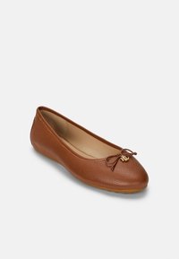 Brown leather ballet flats with a textured finish, rounded toe, and a decorative bow accent featuring a gold logo.