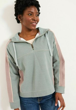 Hellgrüner Hoodie mit Reißverschluss, ausgestattet mit pinken Seitenpaneelen und strukturiertem Stoff. Enthält eine Kordelzugkapuze und gerippte Bündchen. Lässige Passform.