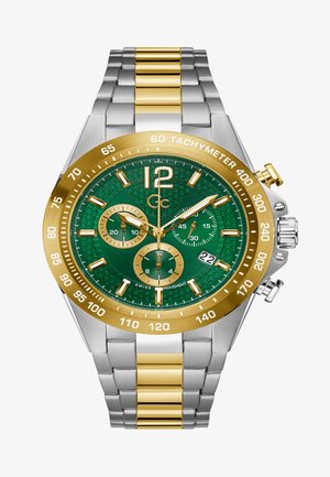 Kronograaf kellal on roheline mustriga kelladial, kullast bezel ja hõbedaste linkidega käevõru, millel on kuldsed aktsendid. Kuvab kolme aladiiali ja kuupäeva.