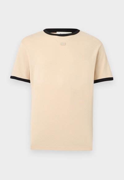 Μπεζ κοντομάνικο μπλουζάκι με μαύρο περίγραμμα στο γιακά και στις άκρες των μανικιών, με ένα μικρό ασημένιο λογότυπο στο κέντρο κάτω από το λαιμό.