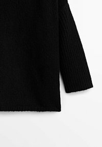Black knitted sweater with a ribbed texture, featuring a wide sleeve design and a straight hem. The fabric appears thick and warm.