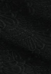 Schwarzer Spitzenstoff mit filigranen Mustern und Strukturen, der ein weiches, transparentes Aussehen hat. Das Design umfasst florale Motive und feine Nähte.