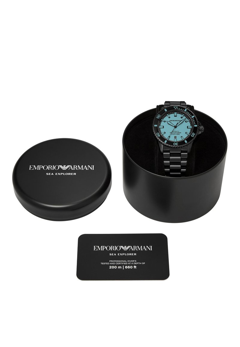 Schwarzes zirkuläres Uhrengehäuse mit blauer Zifferblatt-Uhr, die Stundenmarkierungen, ein Edelstahlarmband und eine Karte mit den Spezifikationen für Taucher enthält.