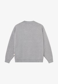 Sweat-shirt gris en tissu doux avec un col ras du cou côtelé, des manches longues et une finition légèrement texturée. Comprend une petite étiquette logo sur le côté.
