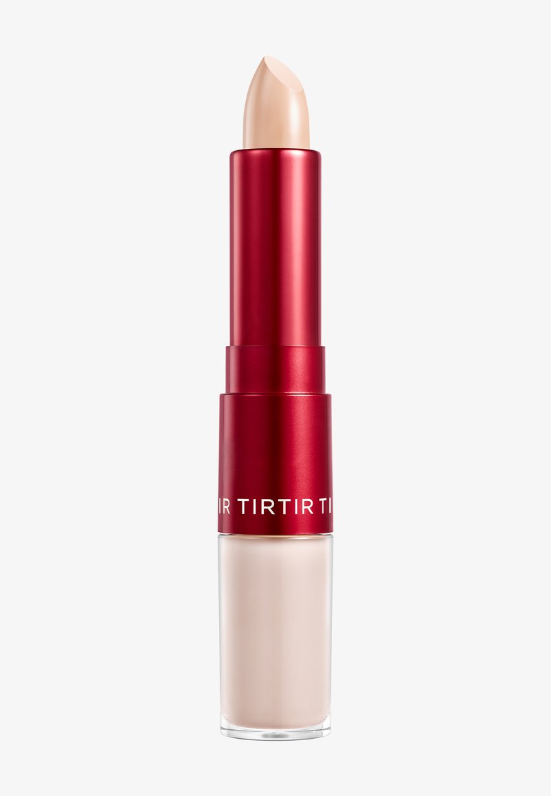 Rouge à lèvres dans un tube en métal argenté et rouge avec une pointe beige arrondie. La partie inférieure est en plastique transparent, mettant en valeur le produit à l'intérieur.