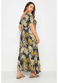 Abito lungo color navy con motivi di foglie dorate, maniche a sbuffo corte, design off-shoulder e tessuto morbido. Lunghissima fino alla caviglia con silhouette fluida.