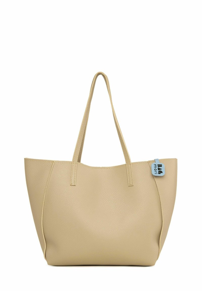 Sac fourre-tout tan avec une finition en cuir texturé, deux longues anses et une forme rectangulaire, présentant un accent de tag bleu sur un côté.