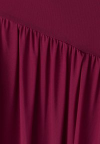 Bordo audinys, viršuje pasižymintis tekstūruotu tinkliuku, kuris žemyn pereina į sugrupuotus klostes, suteikiančias minkštą, laisvai tekančią išvaizdą.