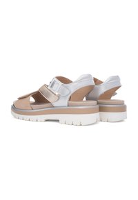 Chunky sandaler i lyse beige og metallisk sølv, med en bred rem, justerbar spænde og en tekstureret hvid sål for godt greb.