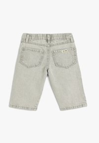 Grå denimshorts med elastisk talje. Har to baglommer og et lille gult mærke på den højre lomme.