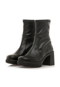 Stivali ankle in pelle nera con tacco quadrato chunky, caratterizzati da una texture liscia e pannelli elastici laterali per una facile calzata.