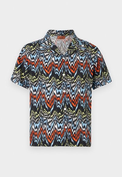 Πουκάμισο με κοντά μανίκια και κουμπιά, με πολύχρωμο ζιγκ ζαγκ μοτίβο σε μαύρο, κόκκινο, μπλε, κίτρινο και λευκό σε λευκό φόντο.